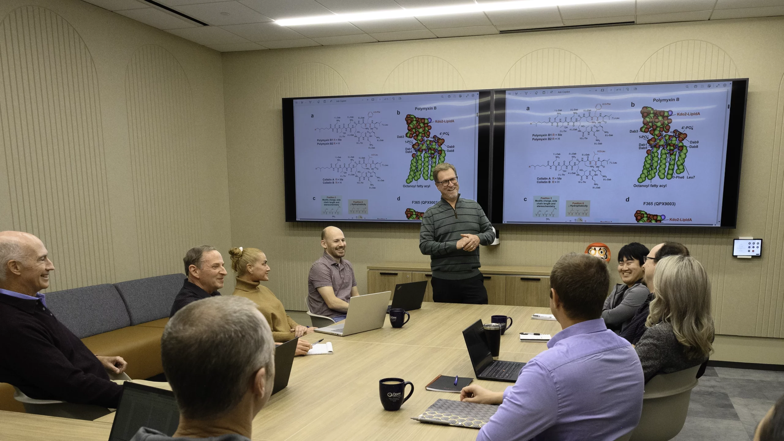 Qpex employees meeting in a conference room.